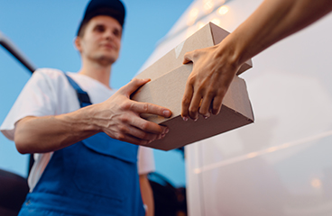 deliveryman gives parcel to female recipient